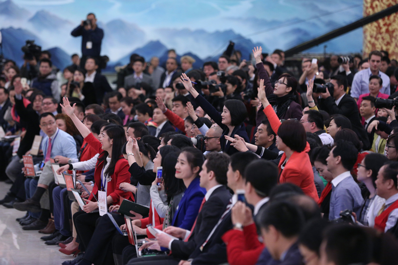 3月15日，國務院總理李克強在北京人民大會堂與中外記者見面，并回答記者提問。這是記者舉手爭取提問機會。 新華社記者 才揚 攝