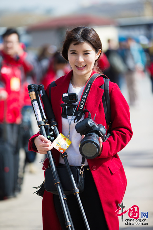 2016年兩會，人民大會大堂前，一位笑容燦爛的紅衣女記者正步入大會堂。中國網(wǎng) 鄭亮 攝
