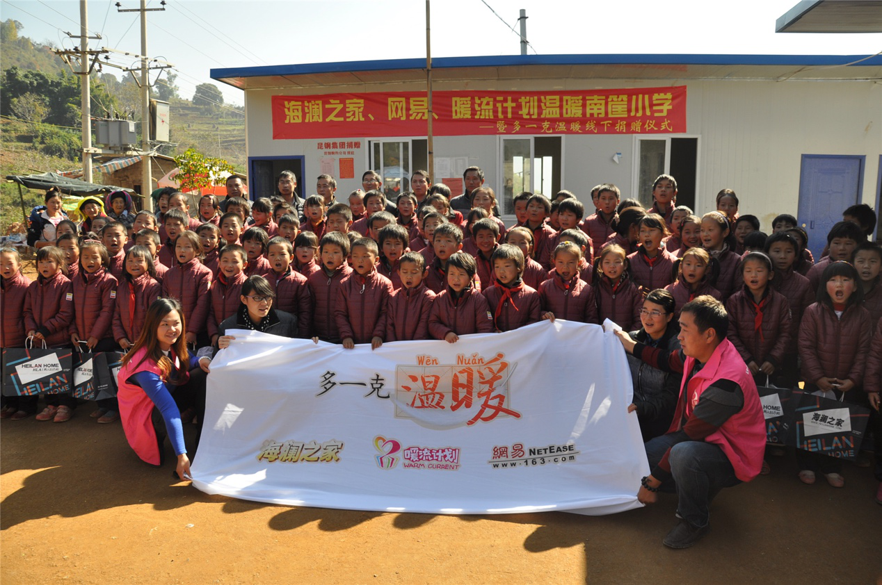 2014年11月20日，“多一克溫暖”公益團隊來到8.3大地震的重災區(qū)——云南省昭通市魯甸縣的南筐小學。越過崎嶇山路，將一批又一批暖心羽絨服送到了師生們的手中，也將社會的關懷和愛意傳遞給了這些可愛的人。