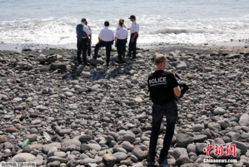 當?shù)貢r間8月2日，法屬留尼旺首府圣但尼附近的一處海灘上，警員正在現(xiàn)場對金屬殘片進行勘察。
